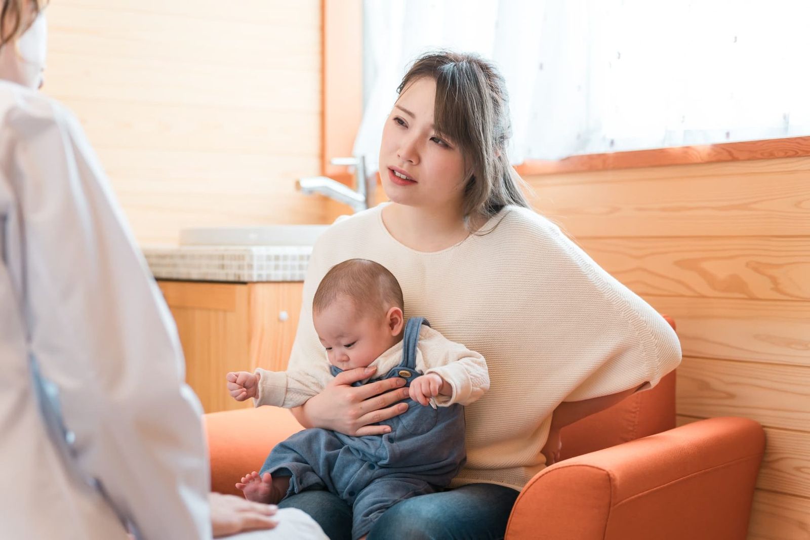 赤ちゃんを抱く産後のママ